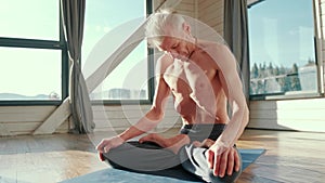 Yoga. Portrait of yogi men doing yoga exercise on blue mat, he breath and performing Upward abdominal lock, Uddiyana