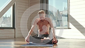 Yoga. Portrait of yogi men doing yoga exercise on blue mat, he breath and performing Upward abdominal lock, Uddiyana