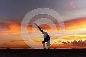 Yoga Poses. Woman Standing Split Asana Or One Foot Up Pose On Ocean Beach. Female Silhouette Practicing Urdhva Prasarita Eka.