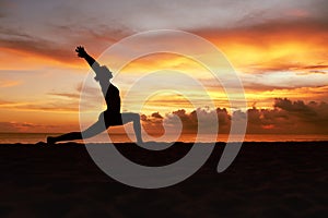 Yoga Poses. Woman Standing In Warrior Pose Asana On Ocean Beach. Female Silhouette Practicing Virabhadrasana At Beautiful Sunset.