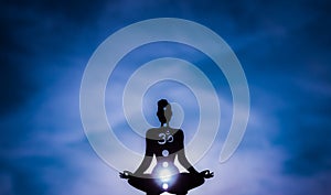 Yoga position silhouette in contrasting sun, Third Eye chakra photo