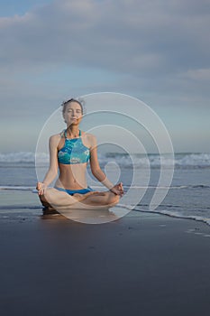 Yoga practice on the beach. Lotus pose. Padmasana. Hands in gyan mudra. Closed eyes. Meditation and concentration. Zen life.