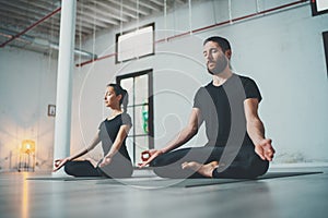 Yoga Practice Exercise Class Concept. Two beautiful people doing exercises.Young woman and man practicing yoga indoors.