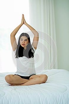 Yoga practice exercise workput lifestyle  Asian woman on white pillow and bed sheet in bedroom relaxing on holiday stay home