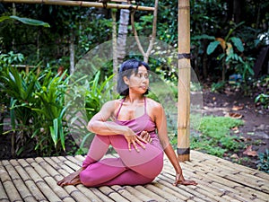 Yoga practice outdoor. Asian yoga teacher practicing Purna Matsyendrasana, Full Spinal Twist pose. Flexible spine. Support immune