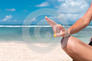 Yoga in the sea or ocean beach. Girl meditating in lotus pose on the tropical island Bali, Indonesia.. Healthy lifestyle