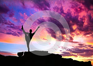 Yoga silhouette on cliff