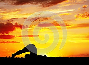 Yoga silhouette Halasana plough pose photo