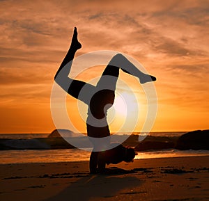 Yoga, silhouette or handstand on sunset beach, ocean or sea in evening workout or relax exercise training. Yogi, woman