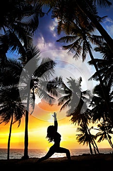 Yoga silhouette near palm trees