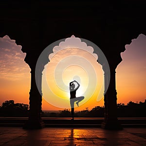 Yoga silhouette in old temple at sunset sky background.