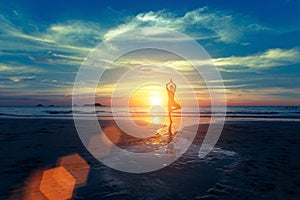Yoga silhouette at sunset on the sea shore