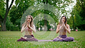 Yoga Slim Women practice Breathing, sit on mats in Park. Squence and Meditation