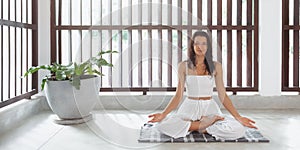 Yoga for the Soul: Meditative Woman in Lotus Pose Practicing Indoors