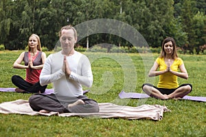 Yoga sportsmen in park - athletes in lotus pose