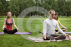 Yoga sportsmen in park - athletes in lotus pose