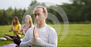 Yoga sportsmen in park - performs exercise outdoors outdoor at morning