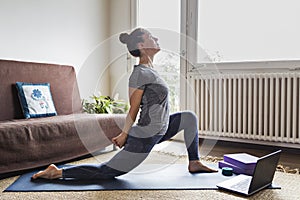 Yoga student doing online video lesson at home