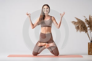 Yoga studio. Fit asian woman in sportswear practicing yoga, keeping balance, while standing on a knees