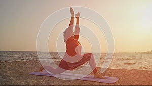 Yoga at sunset on the beach. woman doing yoga, performing asana