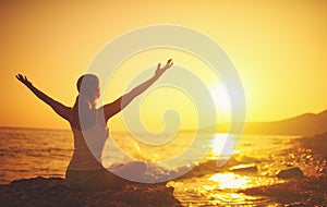 Yoga at sunset on beach. woman doing yoga