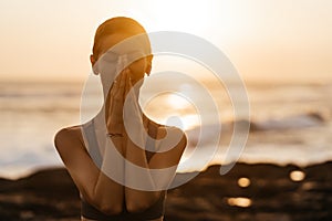 Yoga at sunset on the beach. woman performing asanas and enjoying life on the ocean