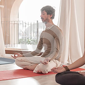 Yoga teachers sitting in the lotus position with their eyes closed. Group of people practicing Yoga.