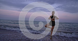 Yoga time in the middle of sea side on the beach lady doing meditation poses in the morning get a fresh air