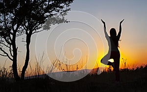 Yoga tree pose by woman silhouette with sunset. Virabhadrasana, Hatha