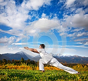 Yoga warrior pose in mountains