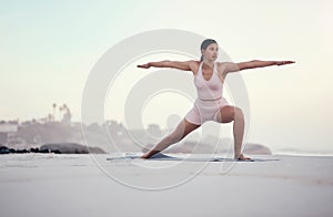 Yoga, warrior pose and woman on the beach doing a meditation for zen in nature. Sea, sand and young person with