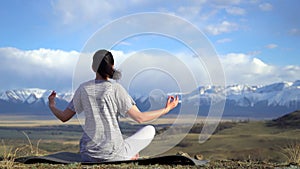 Yoga woman doing meditation yoga exercise in nature on summer on top of mountains