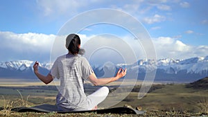 Yoga woman doing meditation yoga exercise in nature on summer on top of mountains
