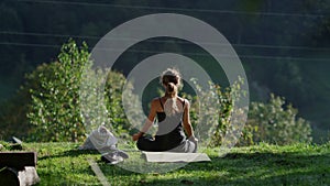 Yoga woman enjoying summer morning outdoors. Happy girl doing yoga in forest.