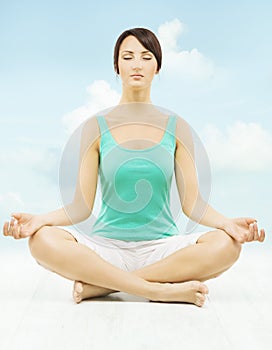 Yoga woman meditate sitting in lotus pose over sky