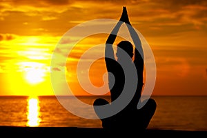 Yoga woman meditating against sea background
