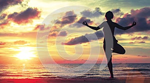 Yoga woman meditating on the beach during sunset