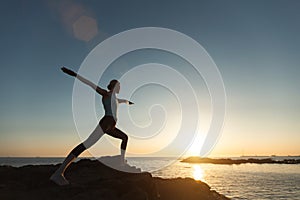 Yoga woman meditating in the lotus position during sunset on the oceanfront