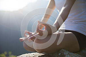 Yoga woman meditating on mountain peak cliff edge photo