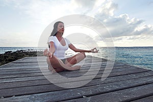 Yoga woman meditating near sea