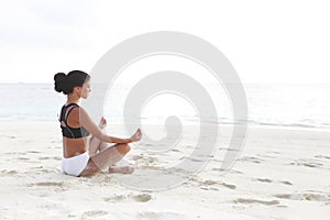 Yoga woman meditating near sea