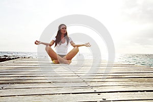 Yoga woman meditating near sea