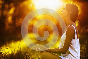 Yoga woman meditating at sunset