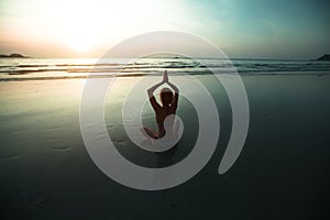 Yoga woman meditation on sunset sea coast.