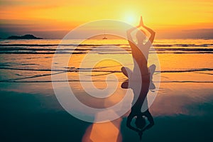 Yoga woman meditation on sunset sea coast