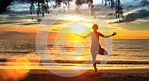 Yoga woman silhouette. Exercises on the beach during a beautiful sunset.