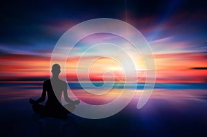 Yoga woman silhouette meditating at sunset colorful sky