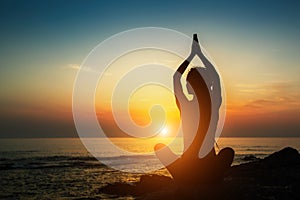 Yoga woman silhouette. Meditation on the ocean. Relax.