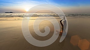 Yoga woman sitting in lotus pose on the beach during amazing sunset.