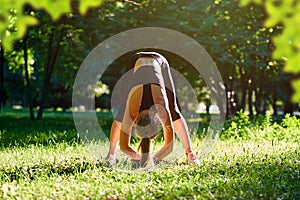 Yoga. Young woman practicing yoga or dancing or stretching in nature at park. Health lifestyle concept